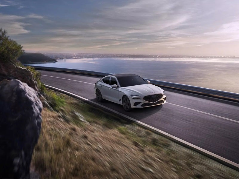 Genesis G70 driving down moutainside highway