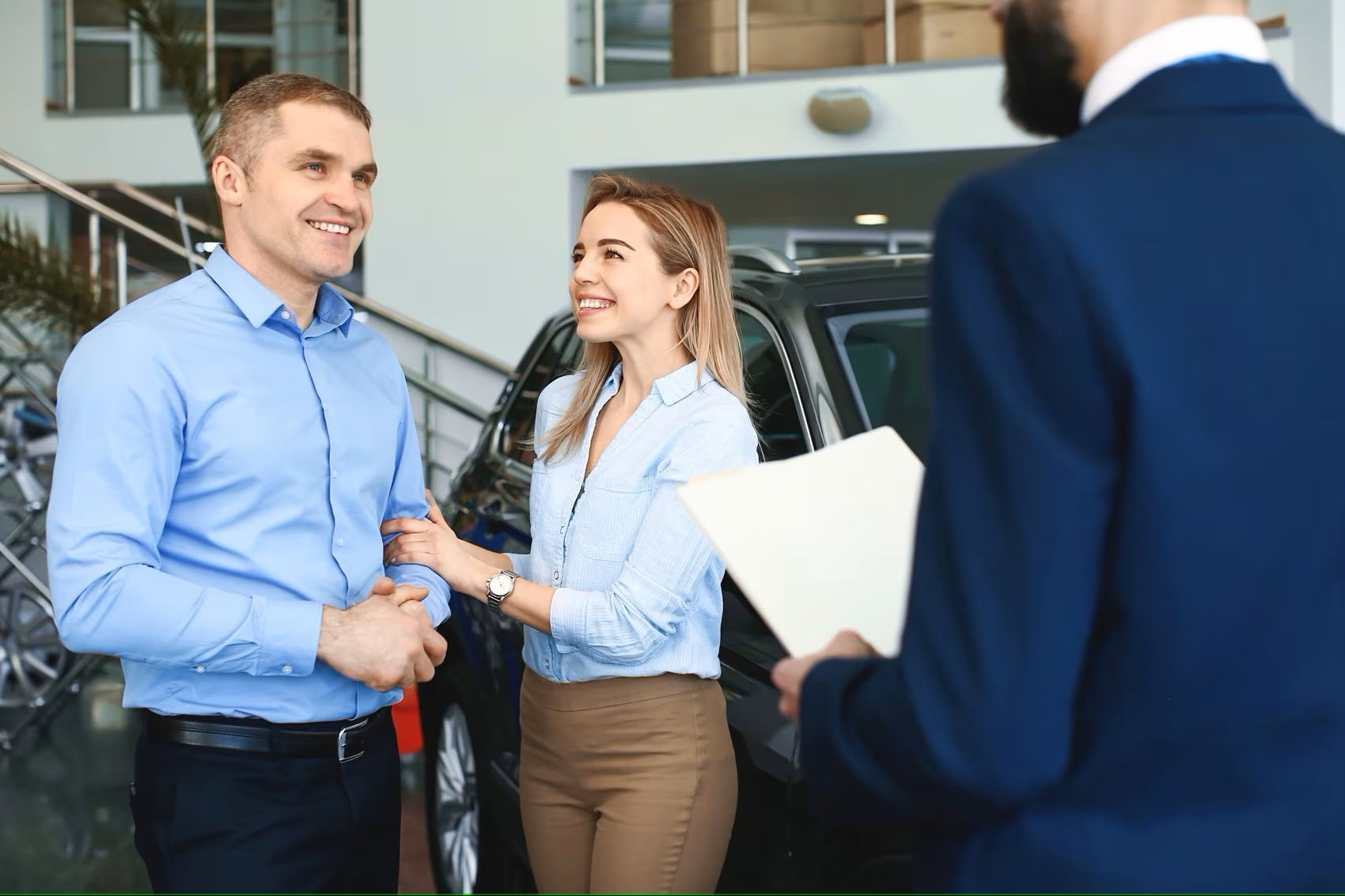 Couple talking to sales manager in showroom