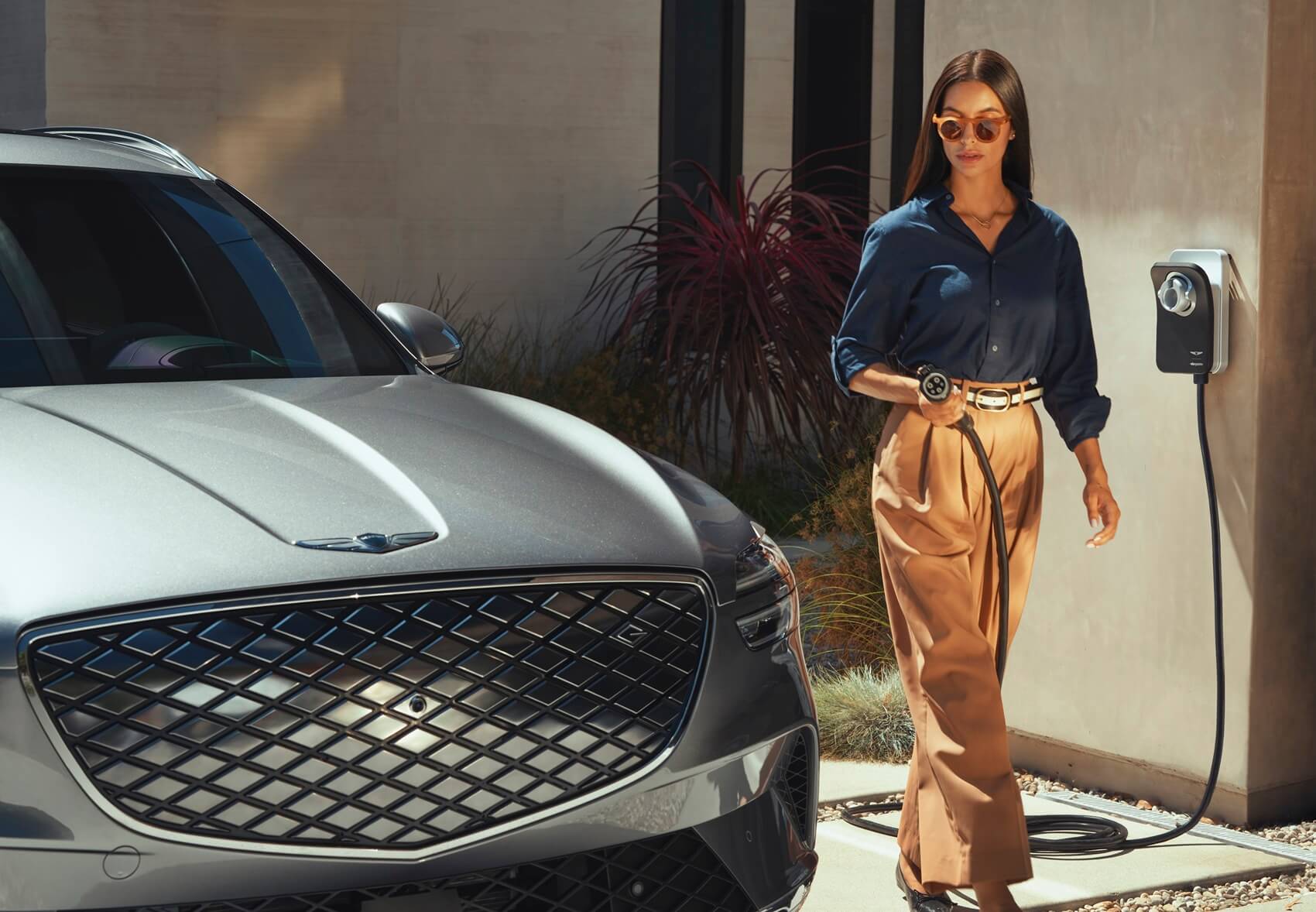 Woman plugging in her Geneis SUV