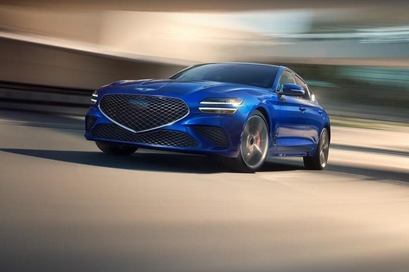 Genesis sedan driving through a city street